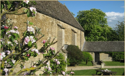 Apple blossom frames the courtyard at Cotswold Woollen Weavers in Filkins